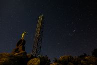 从下方仰望，金属无线电塔在星空映衬下显得格外壮丽