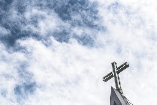 天空多云，教堂尖塔上矗立着充满活力的十字架