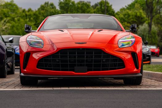 Front view of a sleek red sports car parked, showcasing modern design and vivid color.
