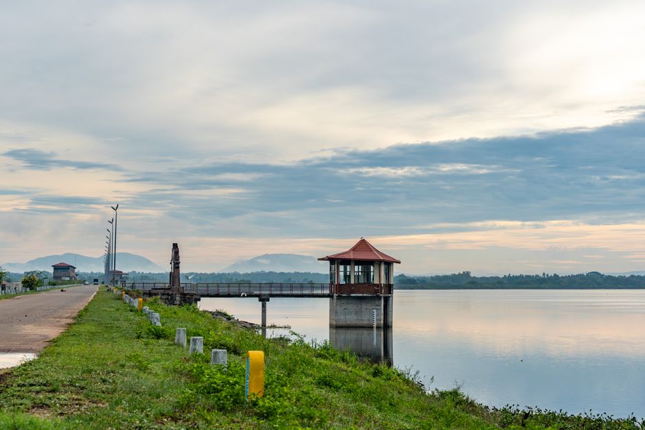 Tranquil lakeside scene in Sri Lanka's North Western Province, featuring a scenic dam structure and mountain backdrop.