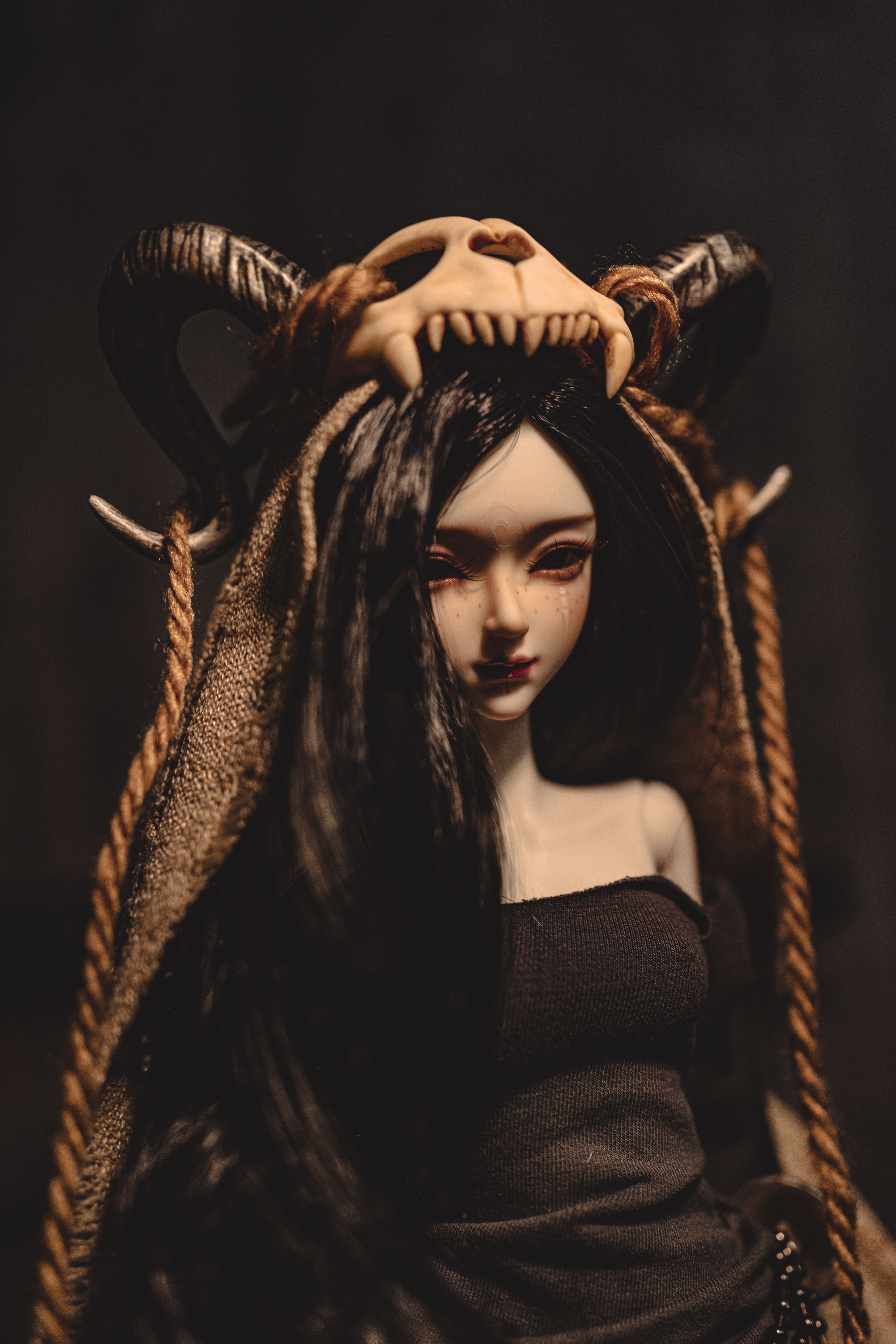Gothic-style doll adorned with a unique headdress featuring horns and dark attire.