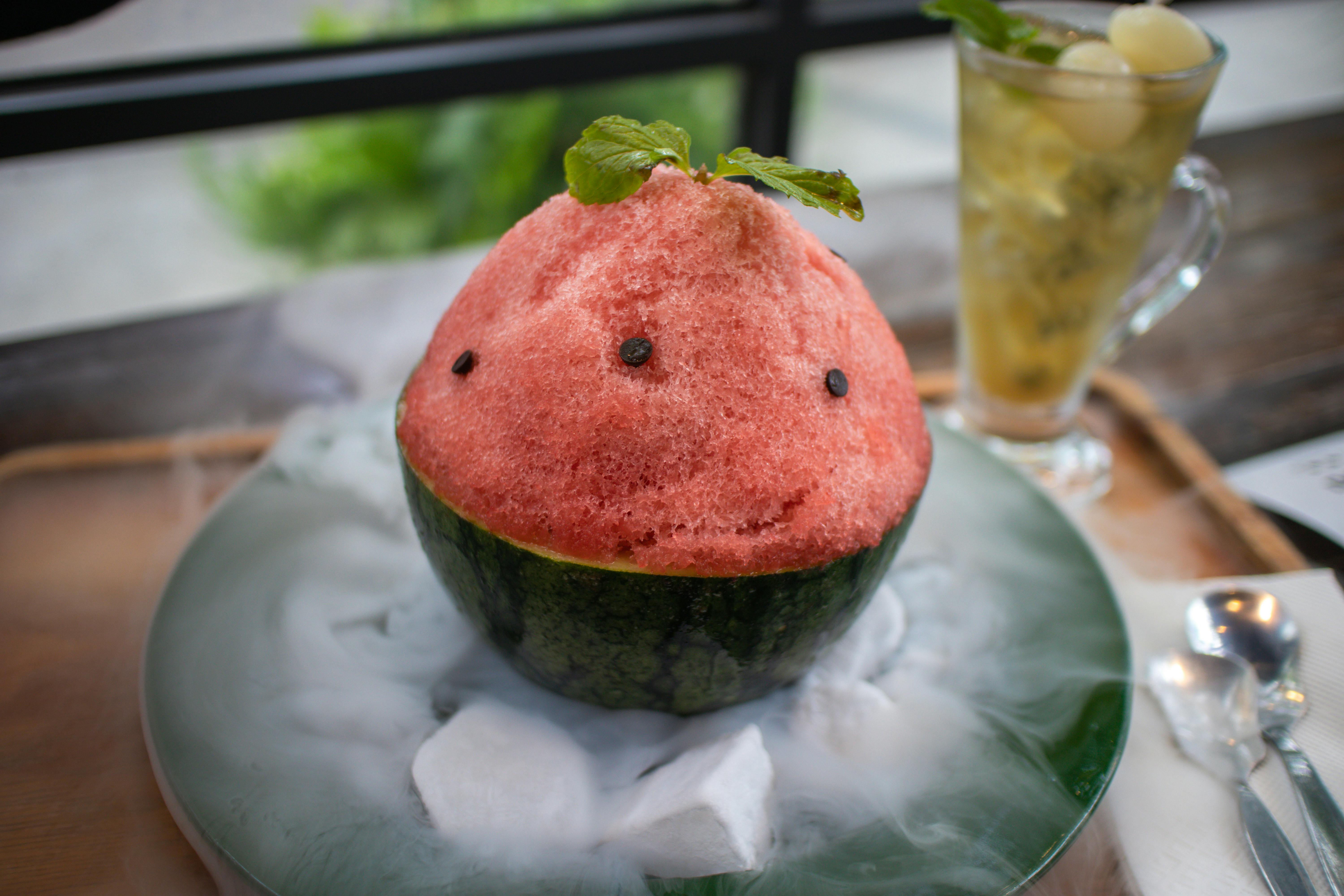 Close-up of a watermelon shaved ice dessert with mint garnish, paired with a refreshing drink. (Photo: Liuuu _61)