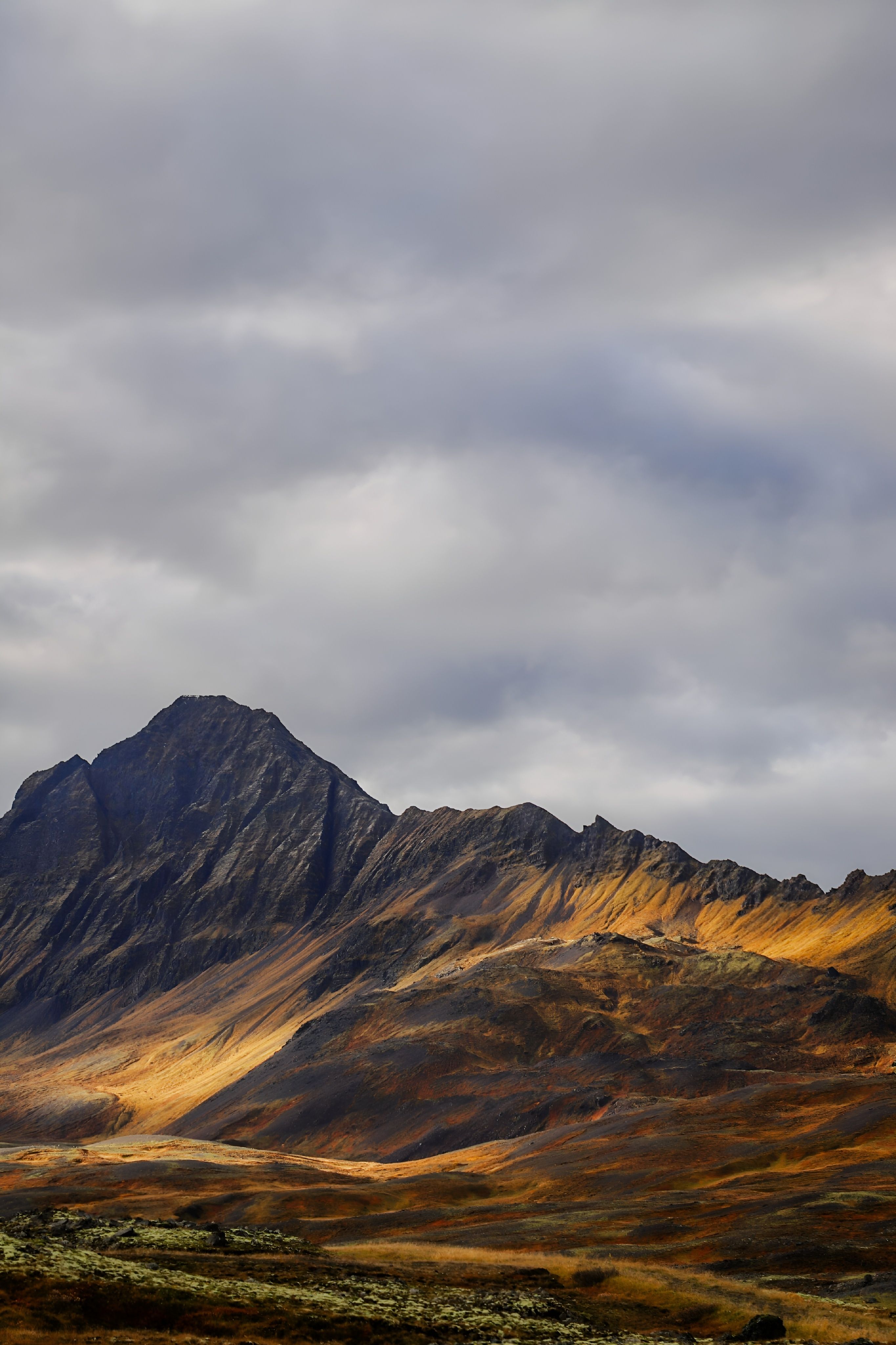 Breathtaking view of rugged mountain peaks on an island under a cloudy sky.