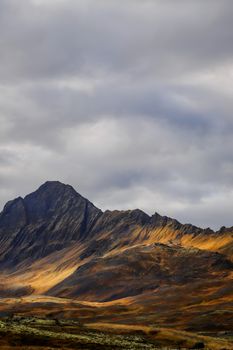 Breathtaking view of rugged mountain peaks on an island under a cloudy sky.