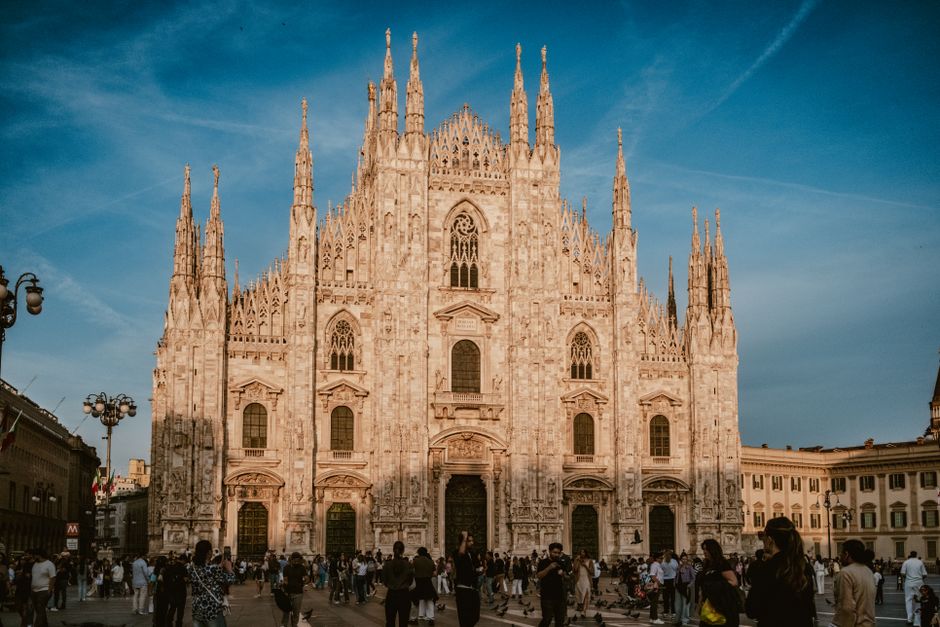 Beautiful facade of Milan Cathedral with a crowd in the vibrant city center. Captivating architectural marvel.
