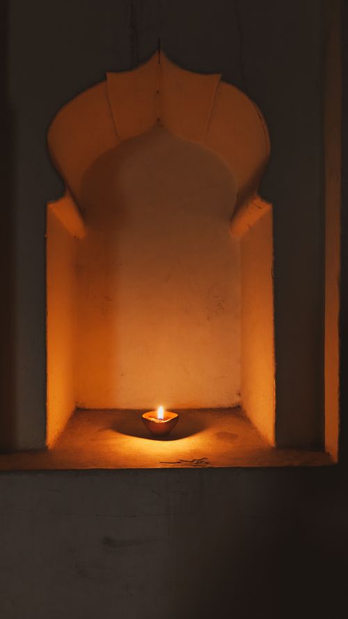 Free A single candle illuminates a traditional alcove, showcasing warm lighting and serene ambiance. Stock Photo