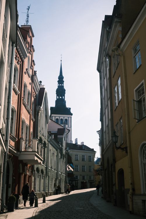 Free A charming street scene in Helsinki showcasing historic architecture and a church spire under a clear sky. Stock Photo
