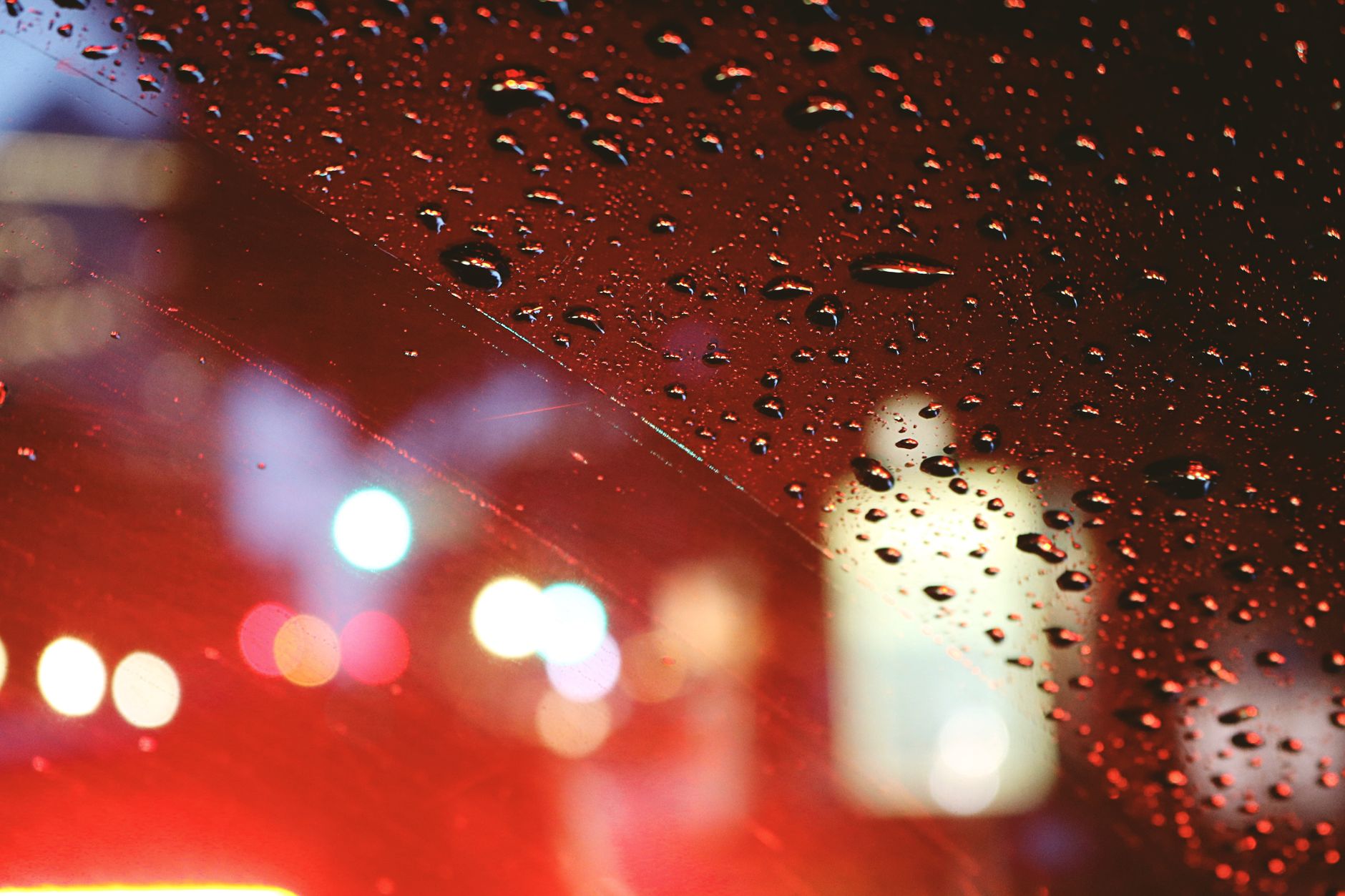 City lights beyond a rain-covered window at night