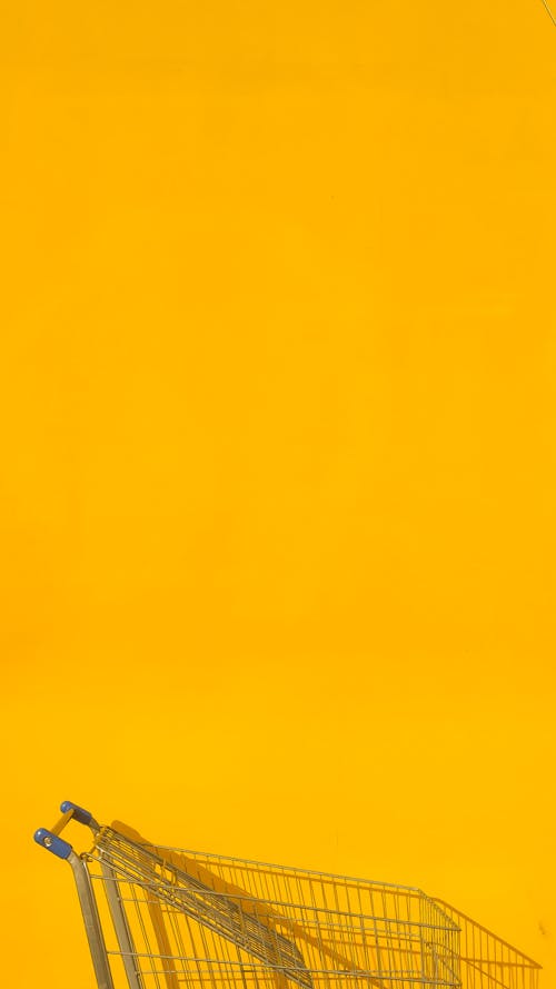 Безкоштовне стокове фото на тему «жовтий фон, кошик поштовху, продуктовий візок» стокове фото