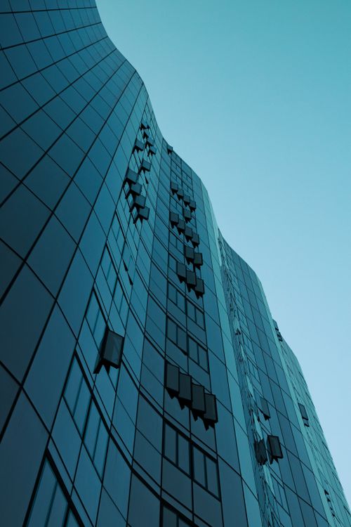 Free Low angle view of a modern skyscraper in Melbourne with a geometric glass facade against a clear sky. Stock Photo