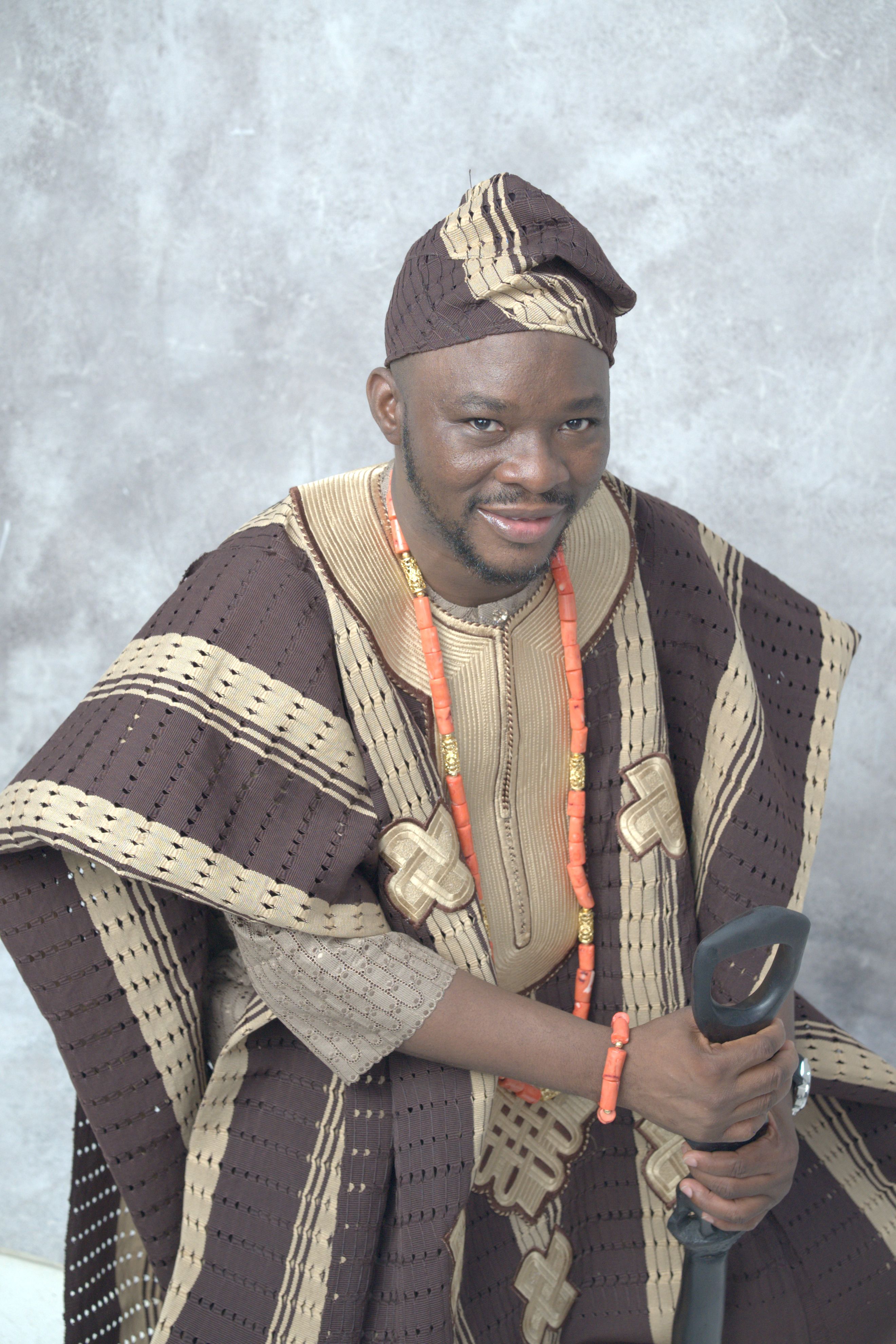 Man in traditional Nigerian attire with beads, showcasing rich cultural heritage.