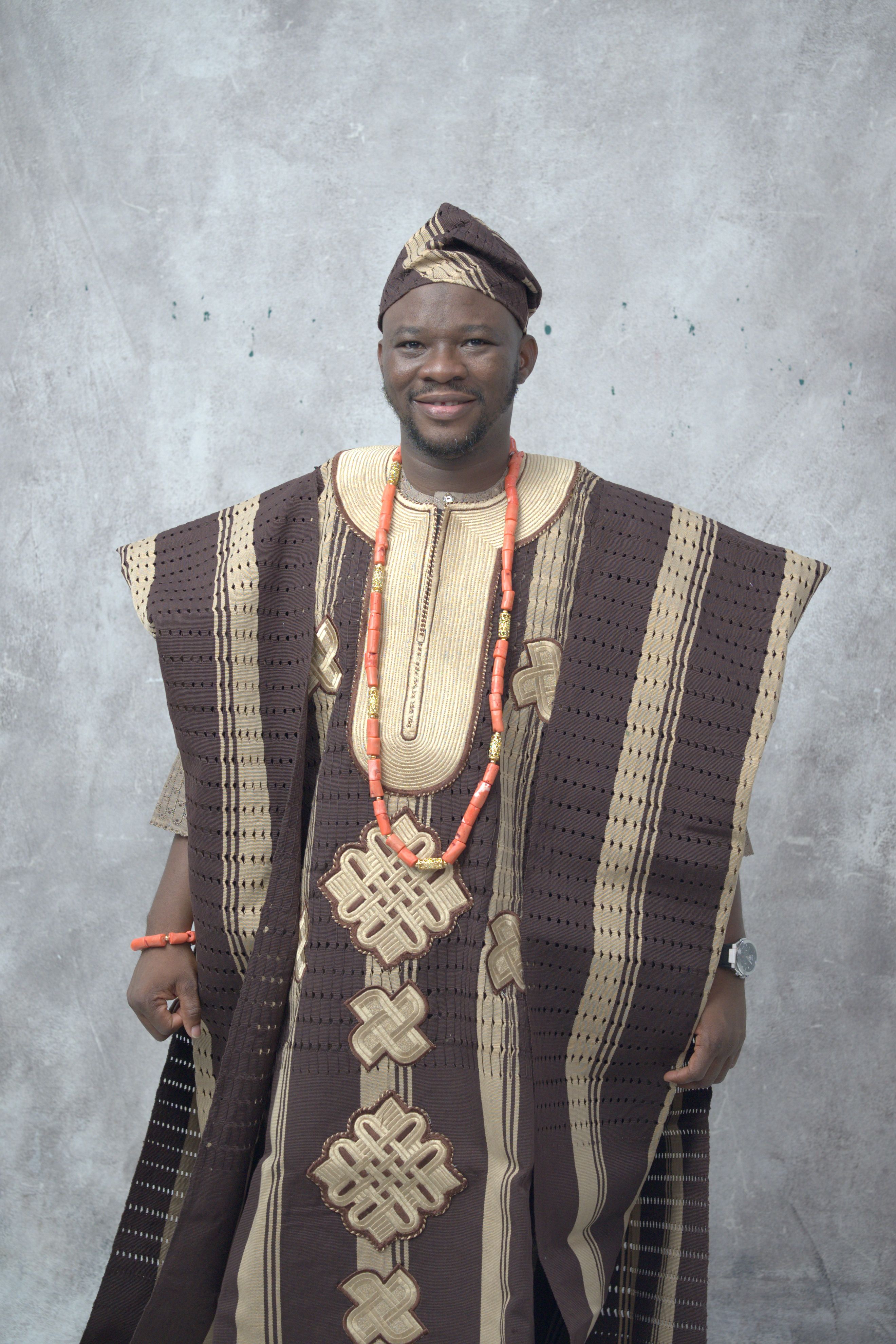 Portrait of an adult Nigerian man wearing traditional attire and beads, exuding cultural pride.
