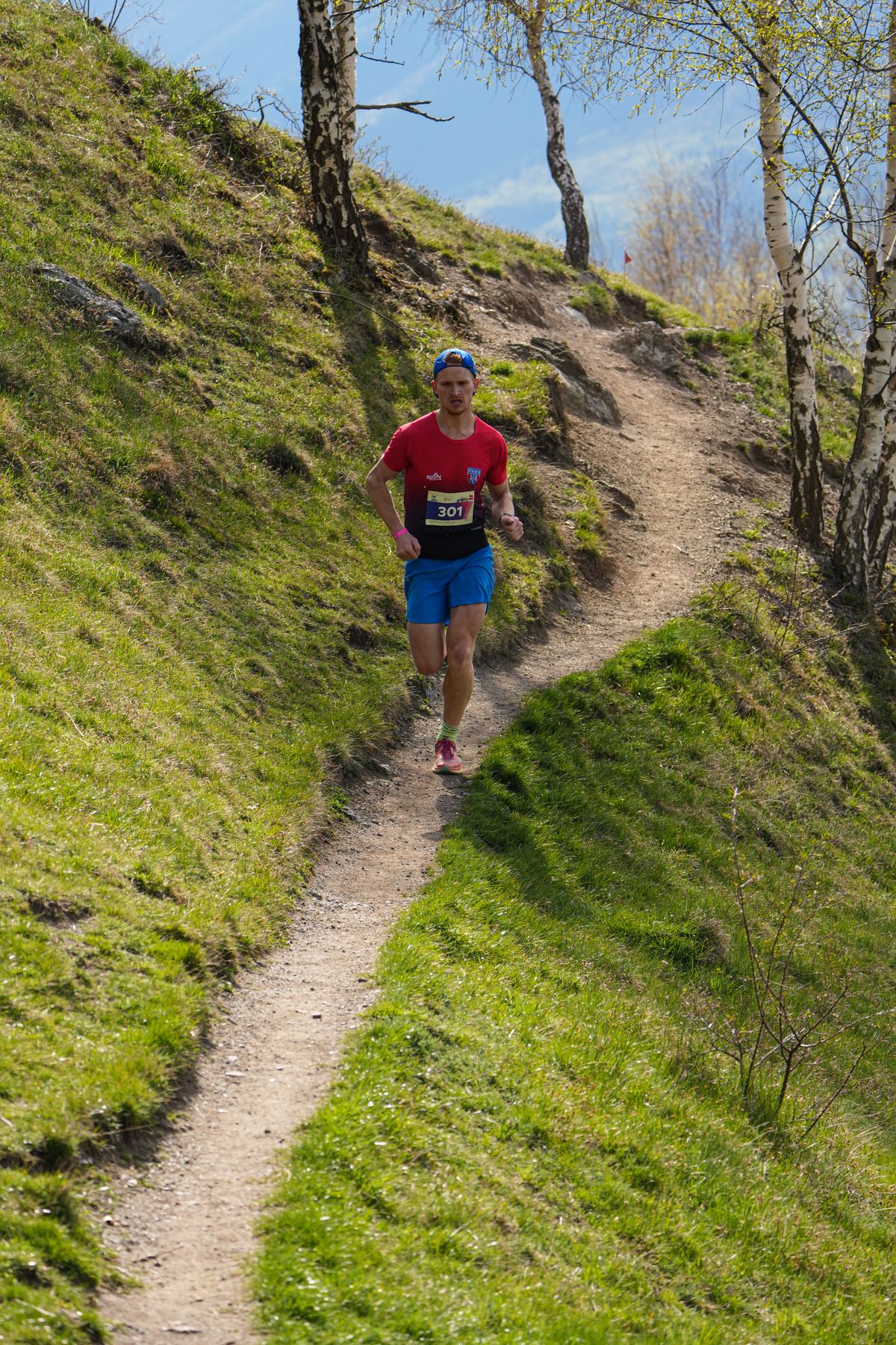 Trail runner wearing sportswear on an outdoor hillside path
