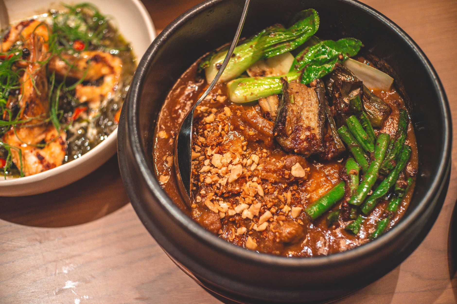 Cooking chicken adobo in a pan showing simmering sauce