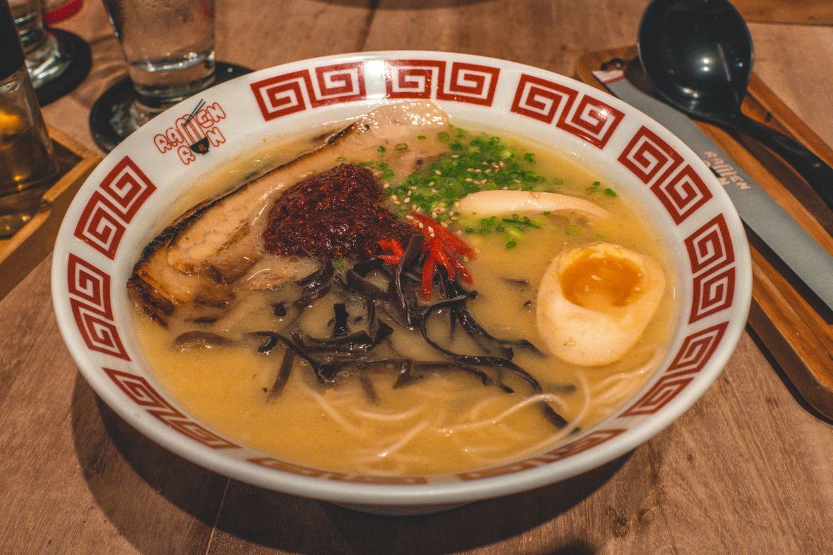 Steaming bowl of Japanese ramen with noodles, broth and toppings