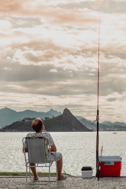 Man Fishing While Sitting on Chair 