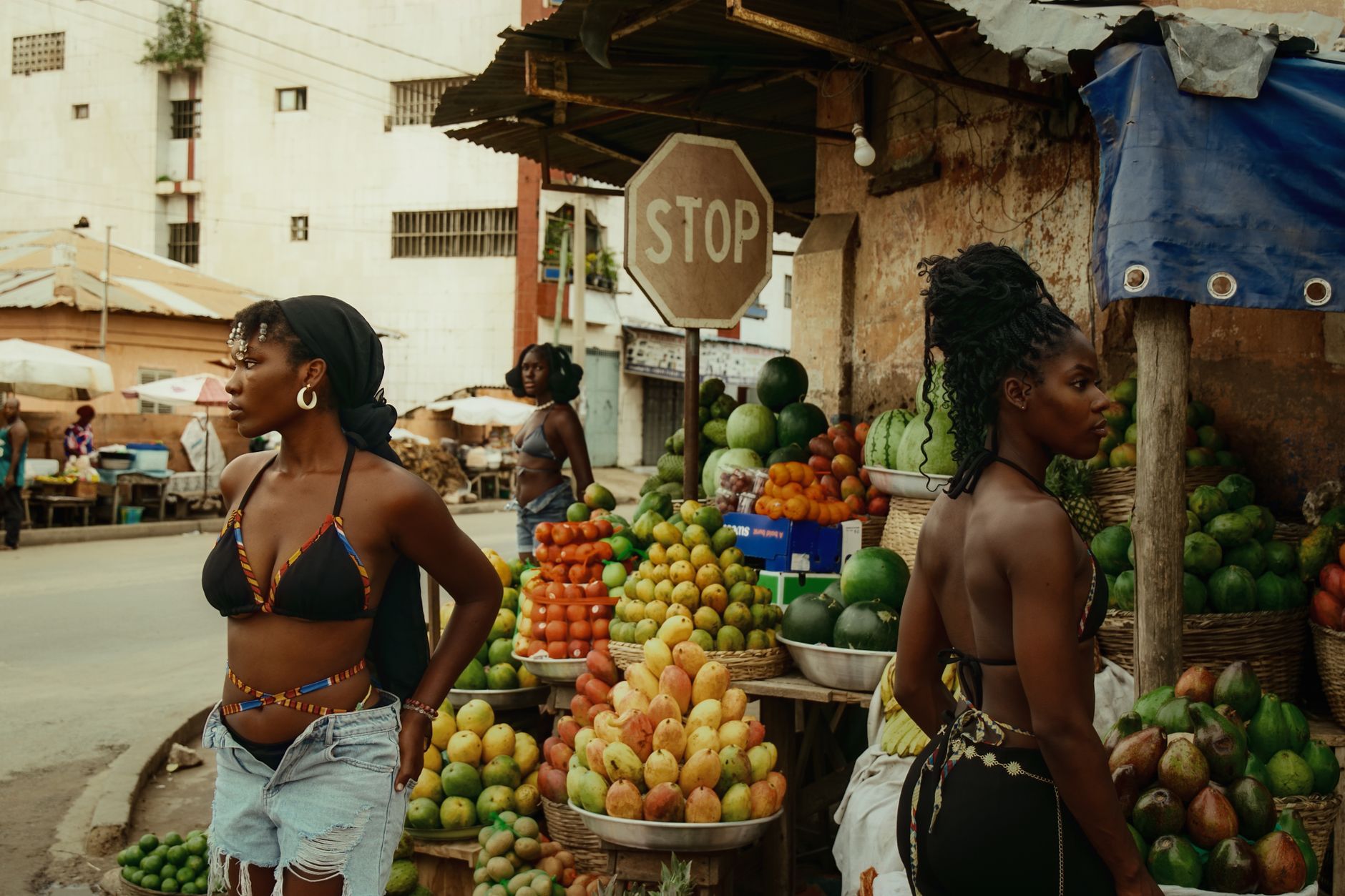 Colorful fruit market in Lomé with people and fresh produce.