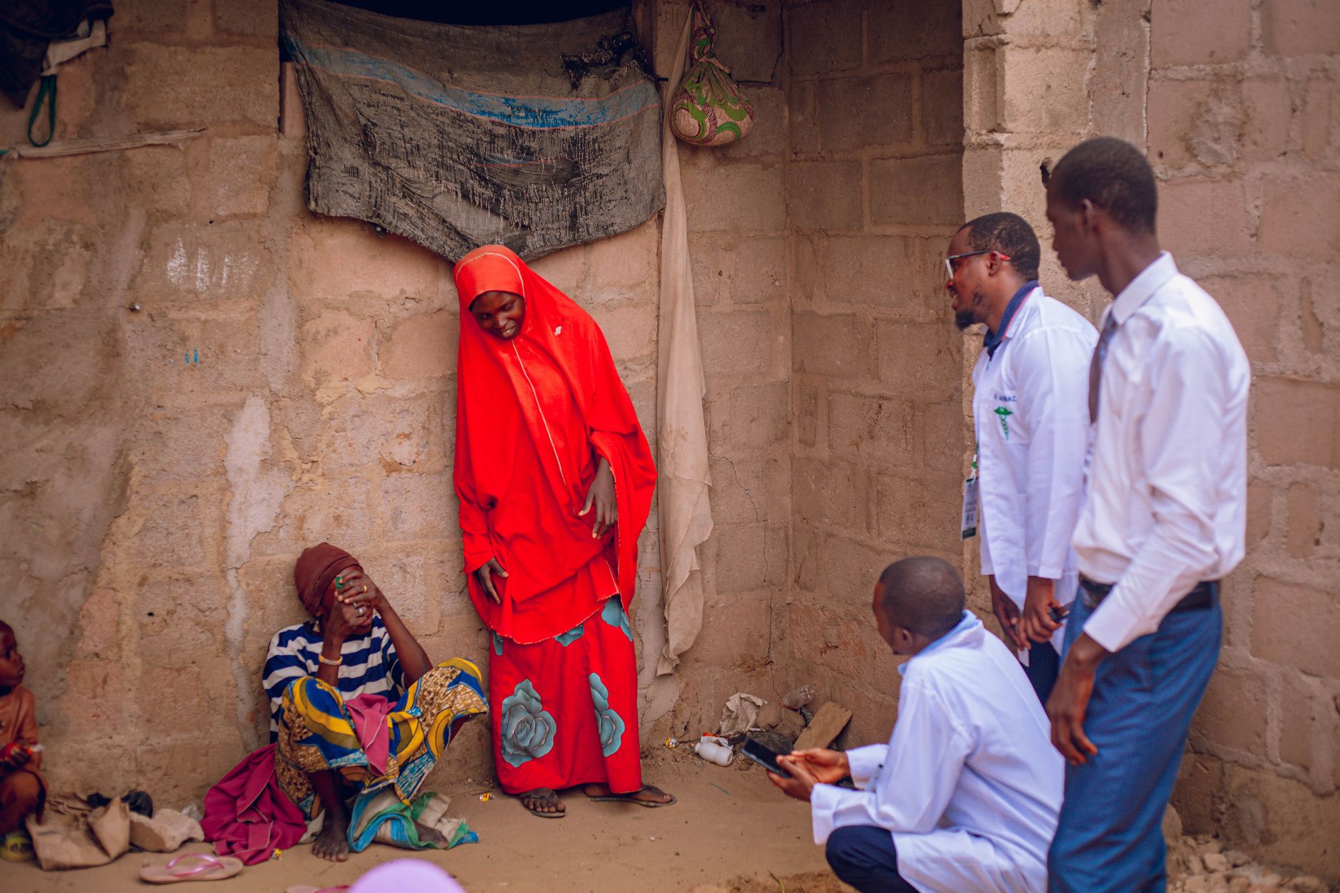 Healthcare professionals engage with villagers in a rural setting in Gombe, Nigeria.