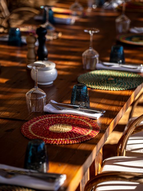 Free Beautifully set outdoor table with colorful mats and glassware under warm sunlight. Stock Photo