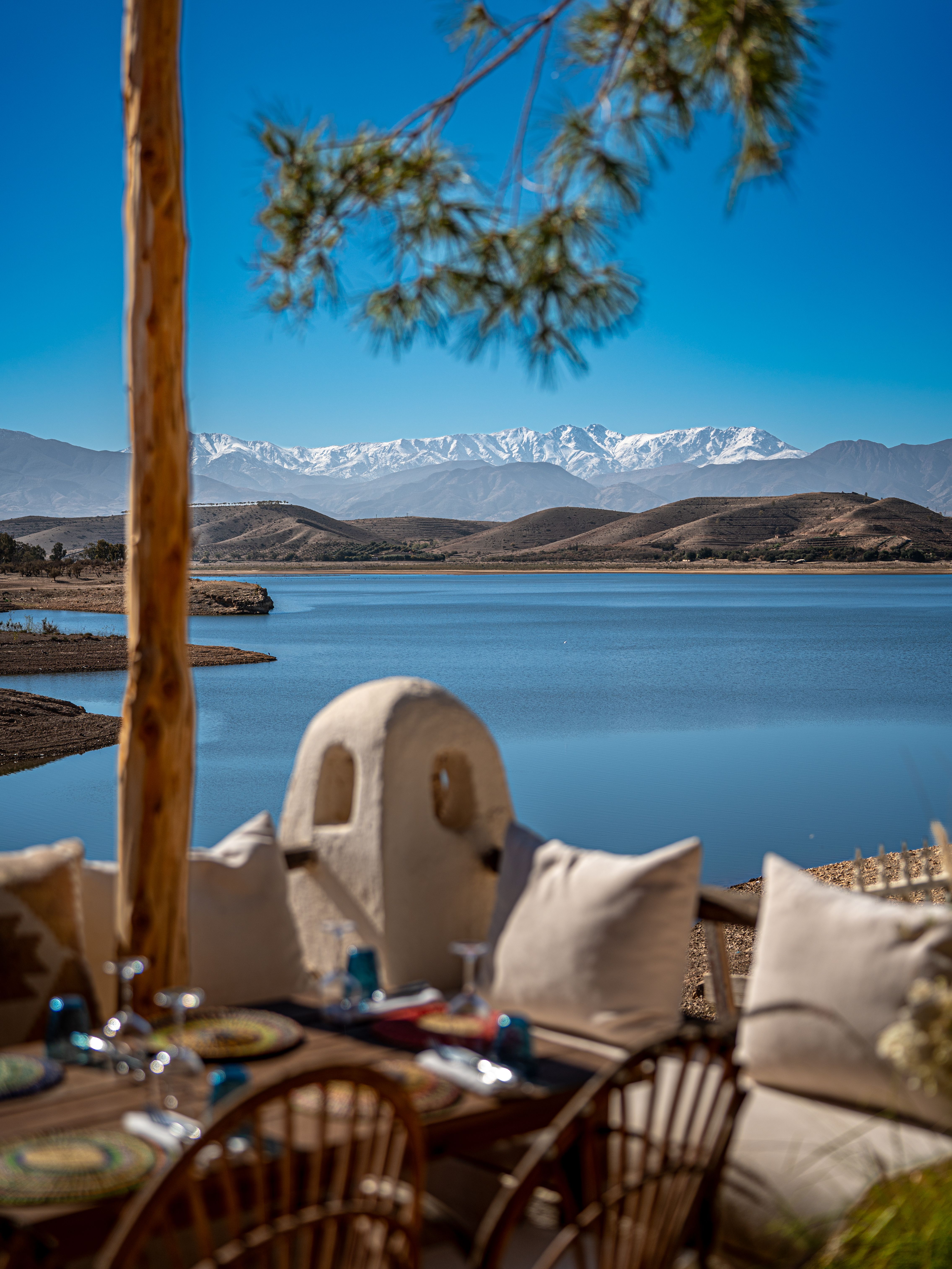 Picturesque lake and snowy mountains from a cozy outdoor setup.
