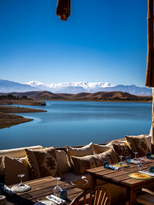 Free Scenic outdoor dining area overlooking a lake with mountains in the background. Stock Photo