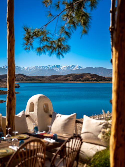 Free Charming lakeside dining spot with stunning mountain backdrop. Stock Photo