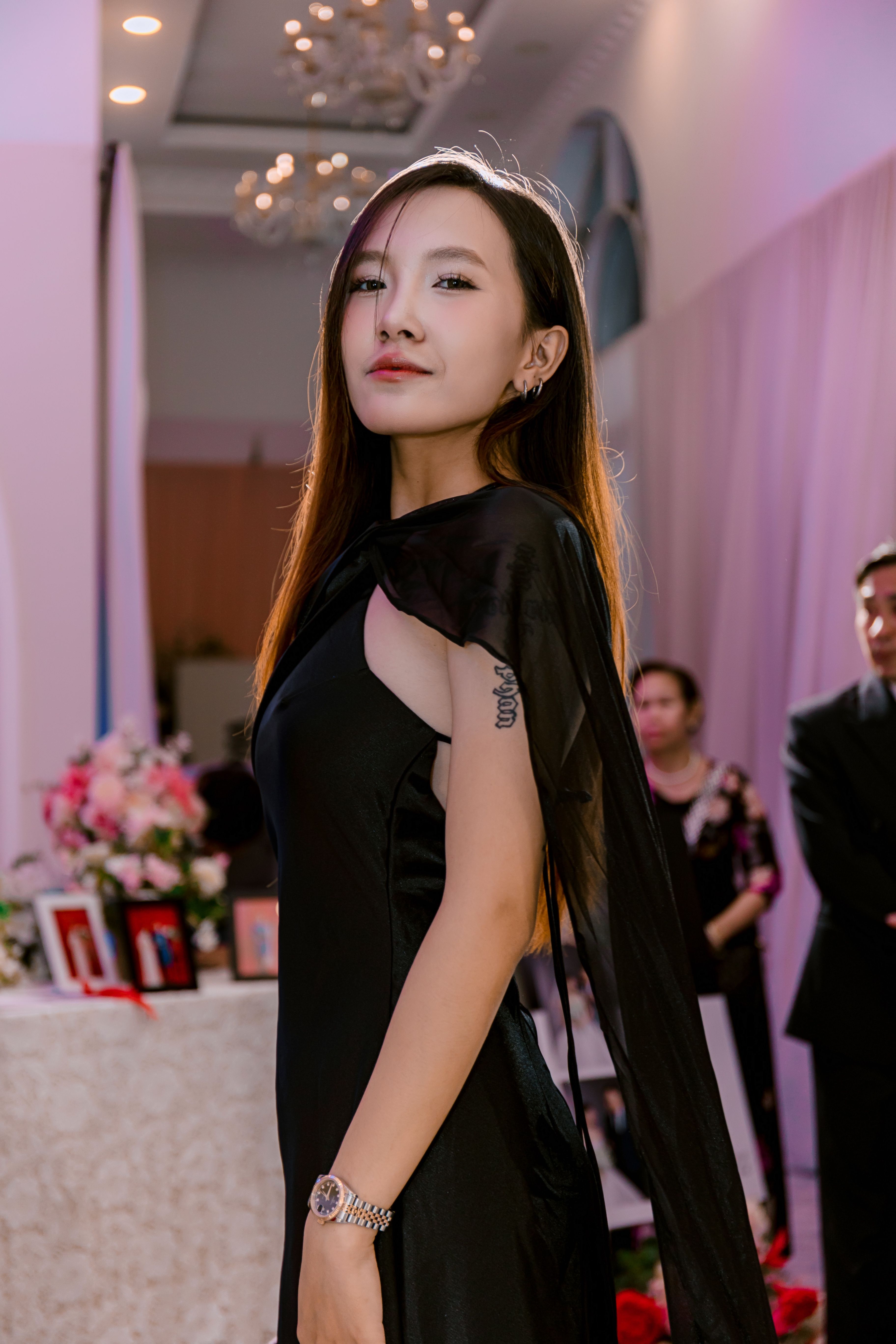 [ColoSach]-a-fashionable-woman-in-a-stylish-black-dress-poses-confidently-at-an-elegant-indoor-event.