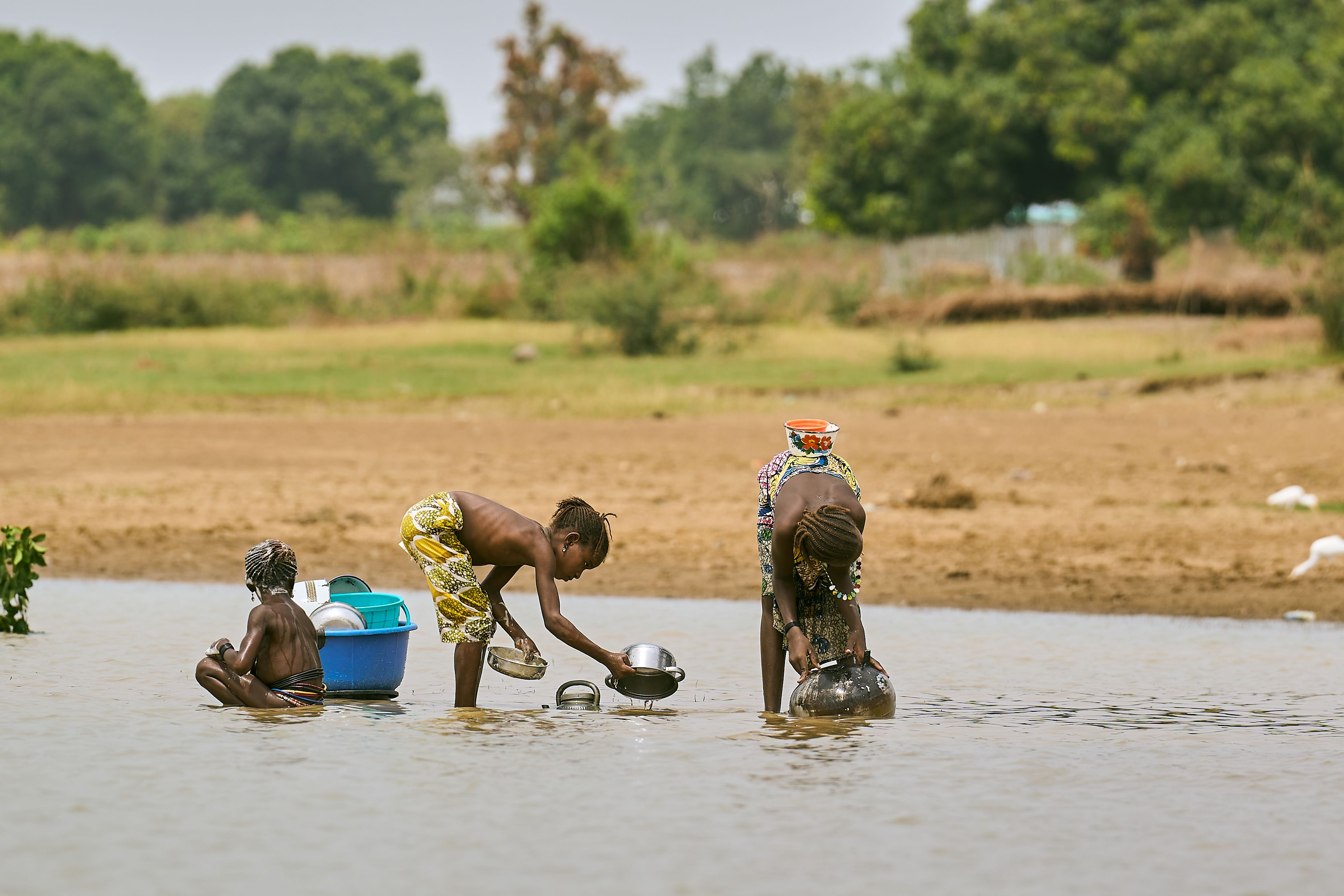 African women washing dishes in Nigerian river · Free Stock Photo