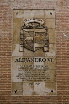 Plaque commemorating Pope Alexander VI in Valencia, Spain features historic text and symbols.