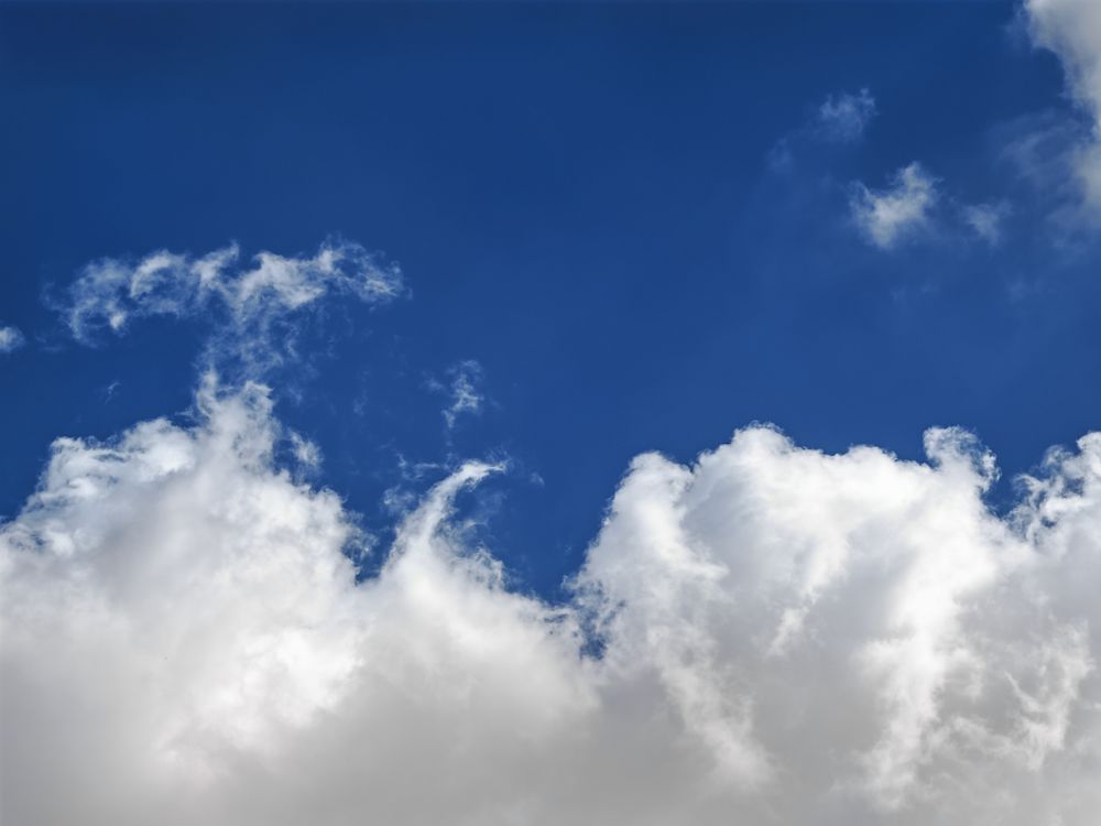 Free Serene view of bright blue sky with fluffy white clouds, perfect for backgrounds. Stock Photo