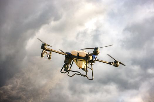 High-tech drone flying amidst dramatic cloudy skies, showcasing advanced technology.