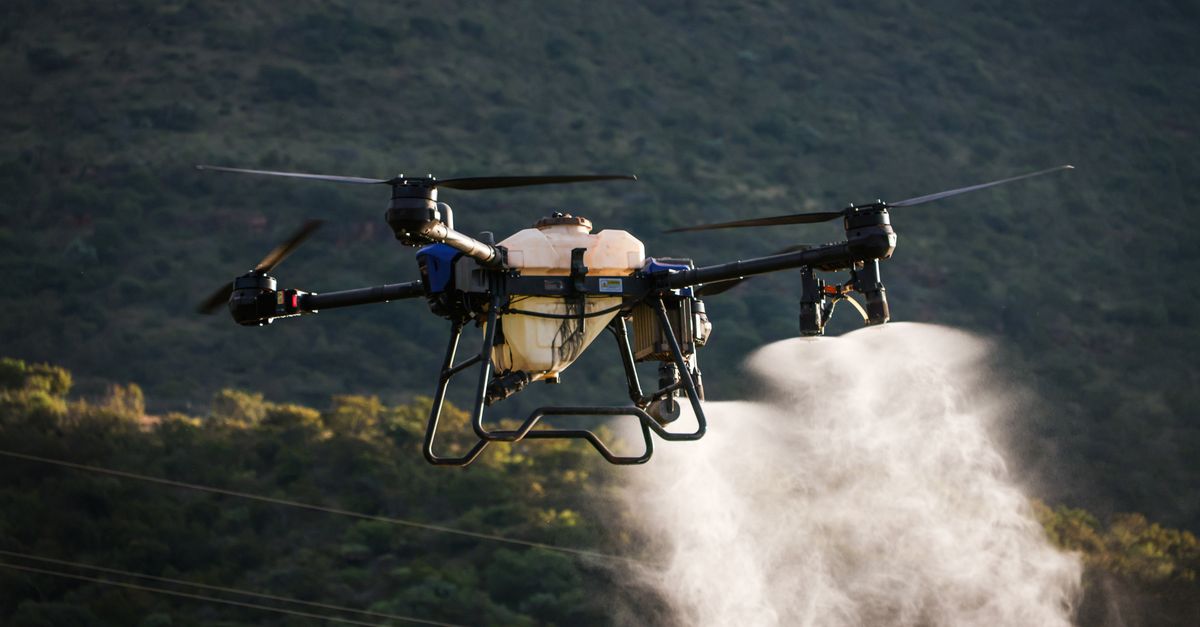 Aerial view of a drone spraying crops with precision agriculture technology.