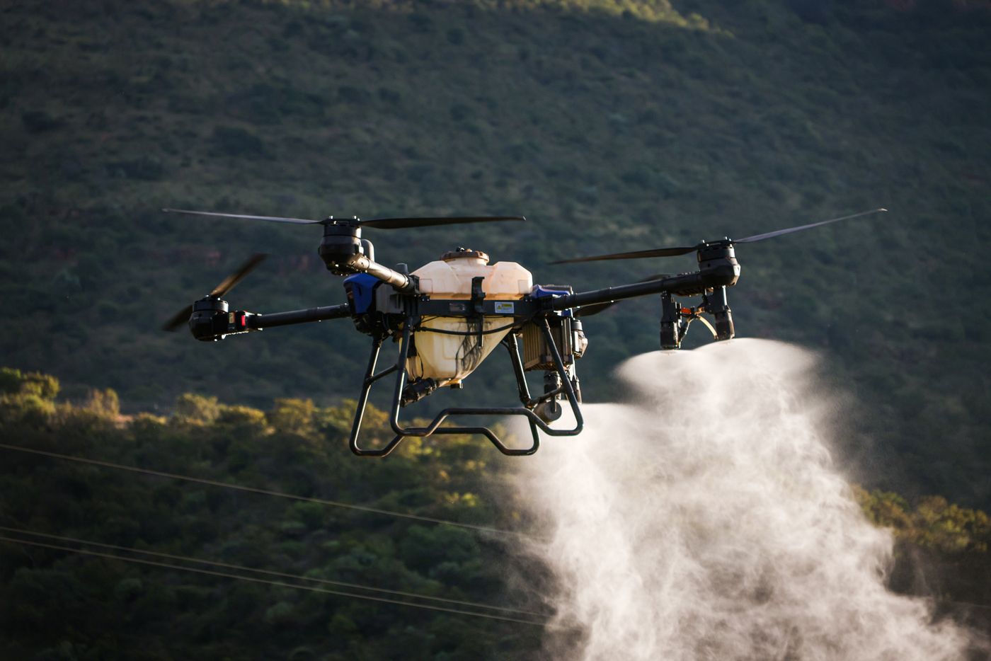 Agricultural drone spraying crops in a field for precision agriculture