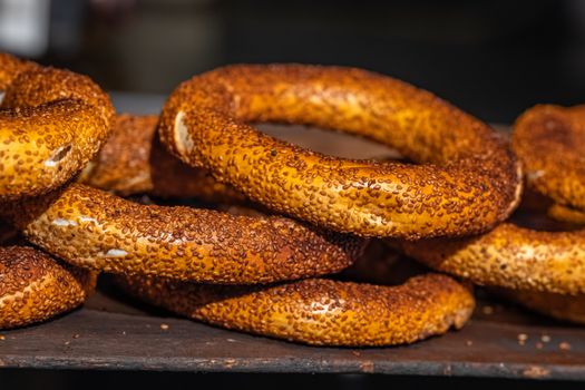 Deliciously crunchy sesame-coated simit rings stacked on display, perfect for a quick street snack.
