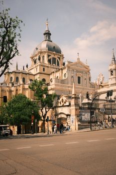 Elegant architectural capture of Almudena Cathedral under a bright sky, showcasing its historic charm in Madrid, Spain.