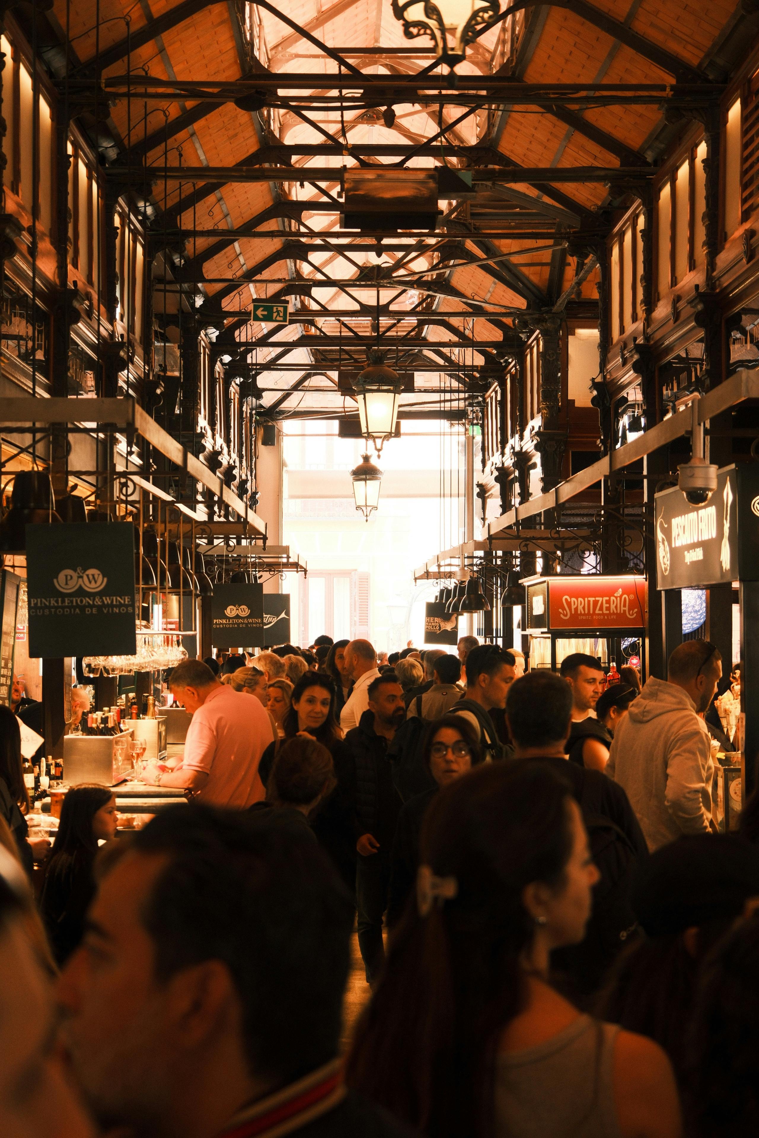 Lively scene of a crowded indoor market with diverse people engaging in shopping.