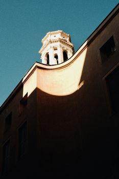 Striking architectural shadows cast on a building in Verona, Italy during sunset.