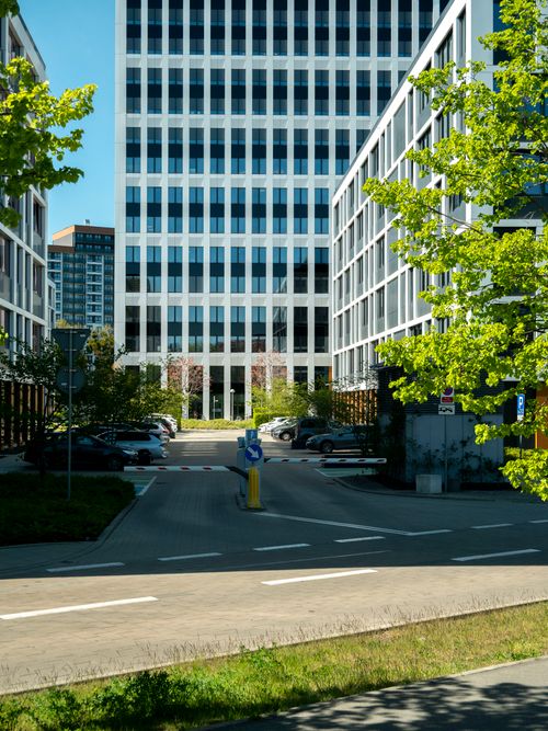 Free Contemporary architecture with green trees lining the street in Wrocław, Poland. Stock Photo