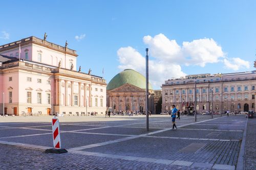 Free A bustling Berlin square with historic architecture and clear skies, capturing everyday life. Stock Photo