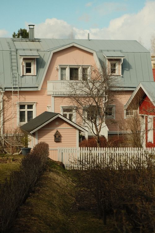 Free A quaint pink house in Lahti, Finland, showcasing traditional architecture and a serene garden path. Stock Photo