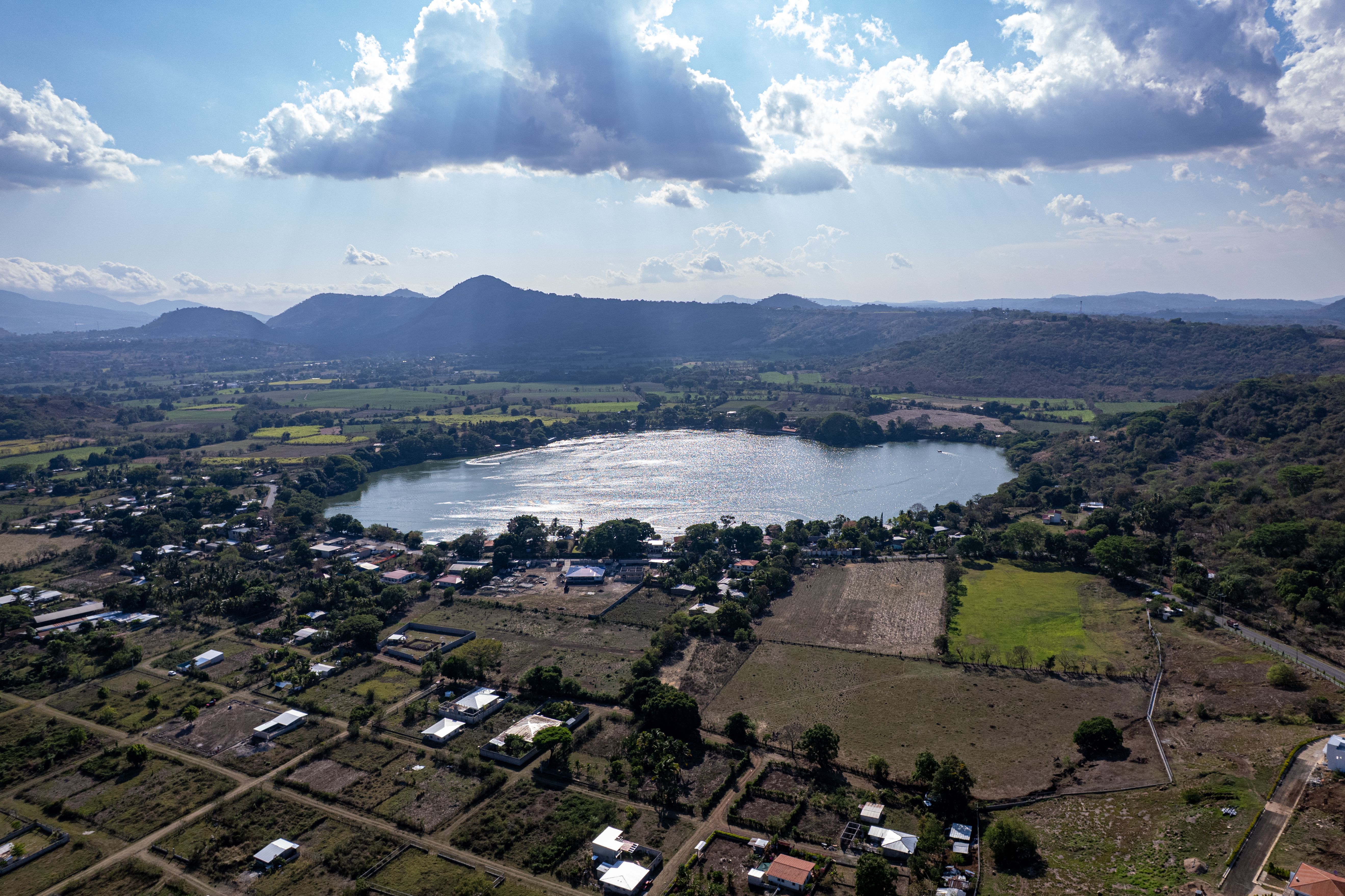 Stunning aerial view of Apastepeque Lake surrounded by lush landscape in San Vicente, El Salvador.