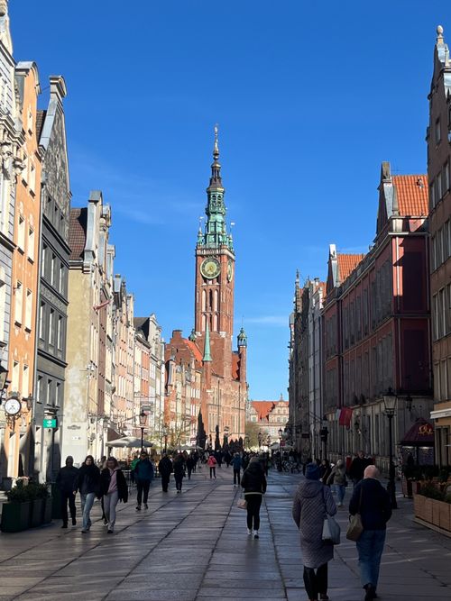 Free Gdańsk's Main Town Hall graces Long Market Street under a clear sky, a bustling scene. Stock Photo