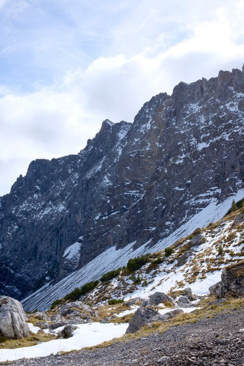 Free Snow-covered rugged mountains in Schwaz, Tirol, Austria with patches of greenery peeking through. Stock Photo