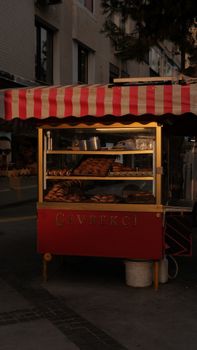 A picturesque street view of a traditional simit stall at sunset in İzmir, Türkiye.