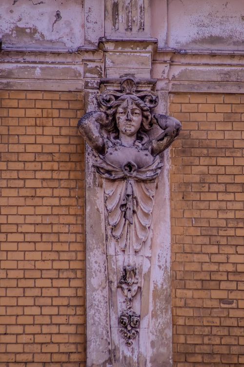 Free Close-up of an intricate architectural sculpture on a brick building facade in Lviv. Stock Photo