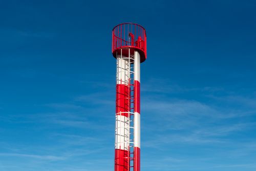 Free Tall red and white metal observation tower set against a clear blue sky, symbolizing exploration. Stock Photo
