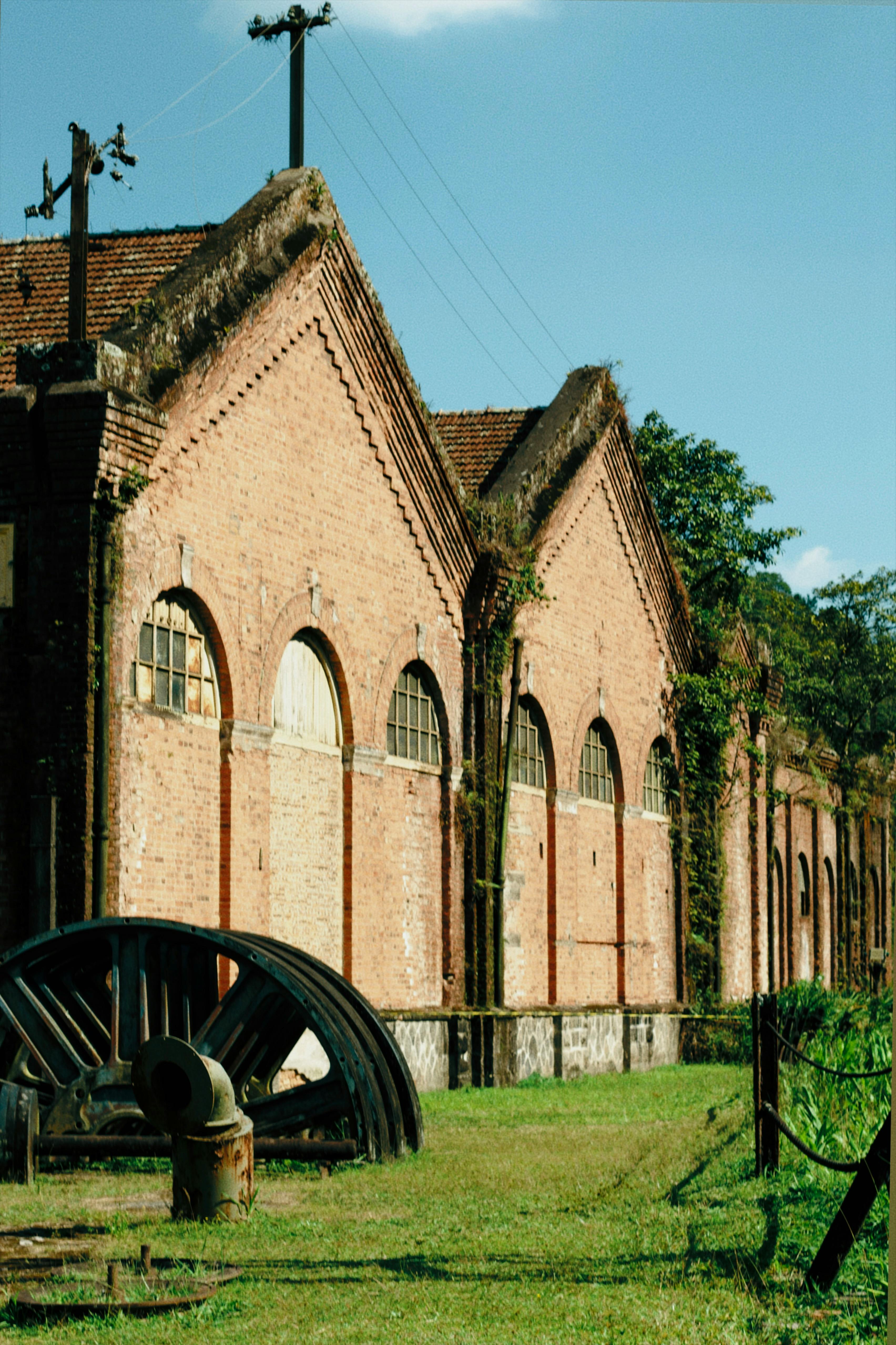 Old brick industrial building with vintage architecture and large metal gear.