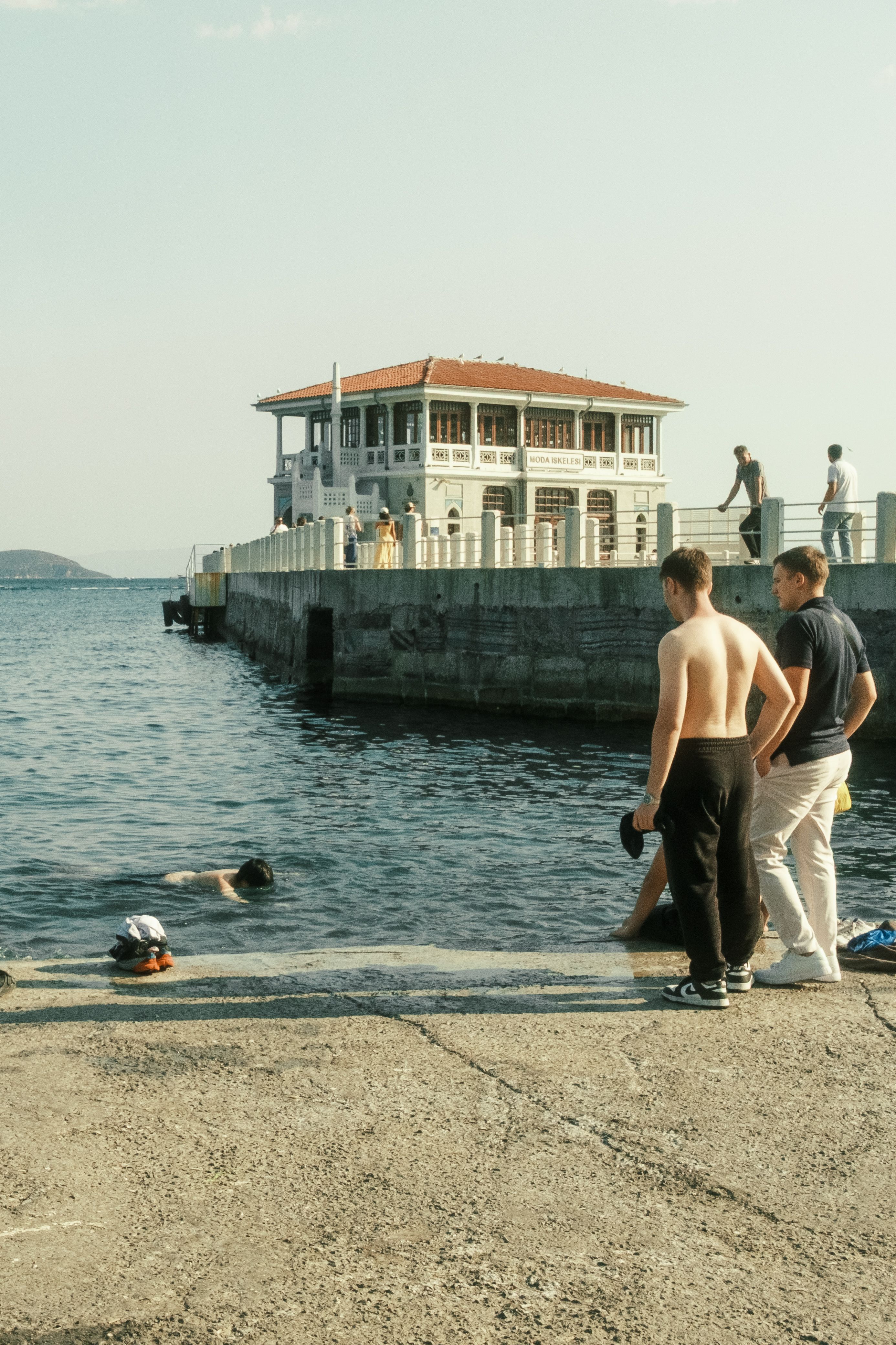 Seaside Swim Near Historical Building · Free Stock Photo