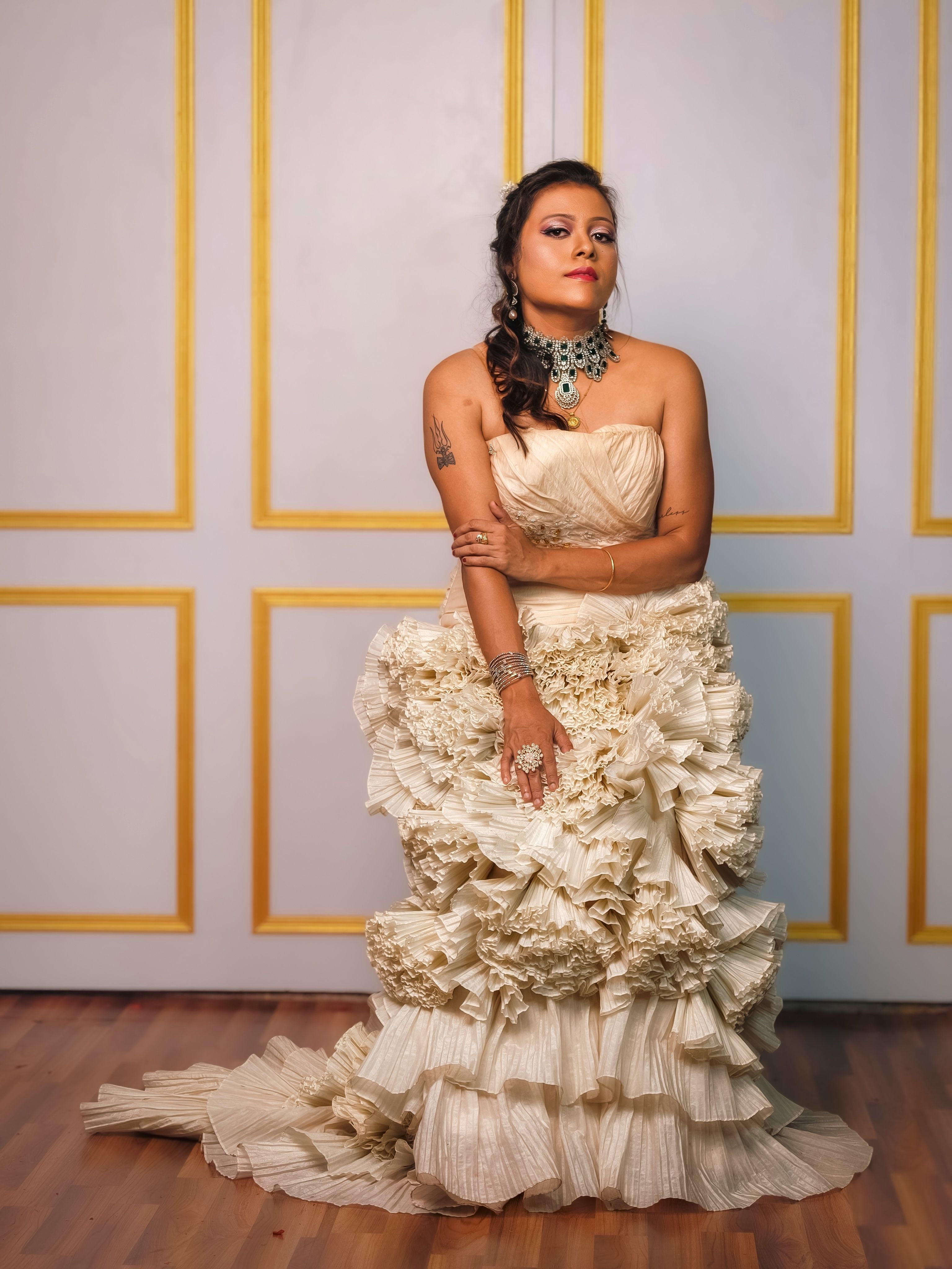 Fashion portrait of a woman in a luxurious cream gown with intricate details, indoors in Kolkata.