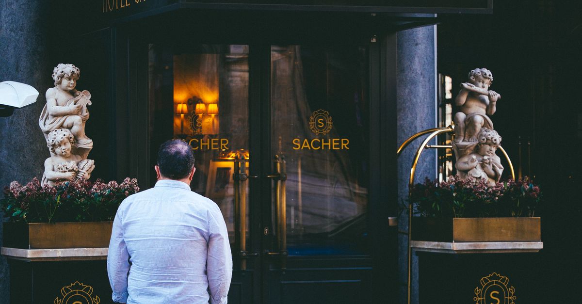 Person standing outside the iconic Hotel Sacher in Vienna, Austria, capturing its grandeur.